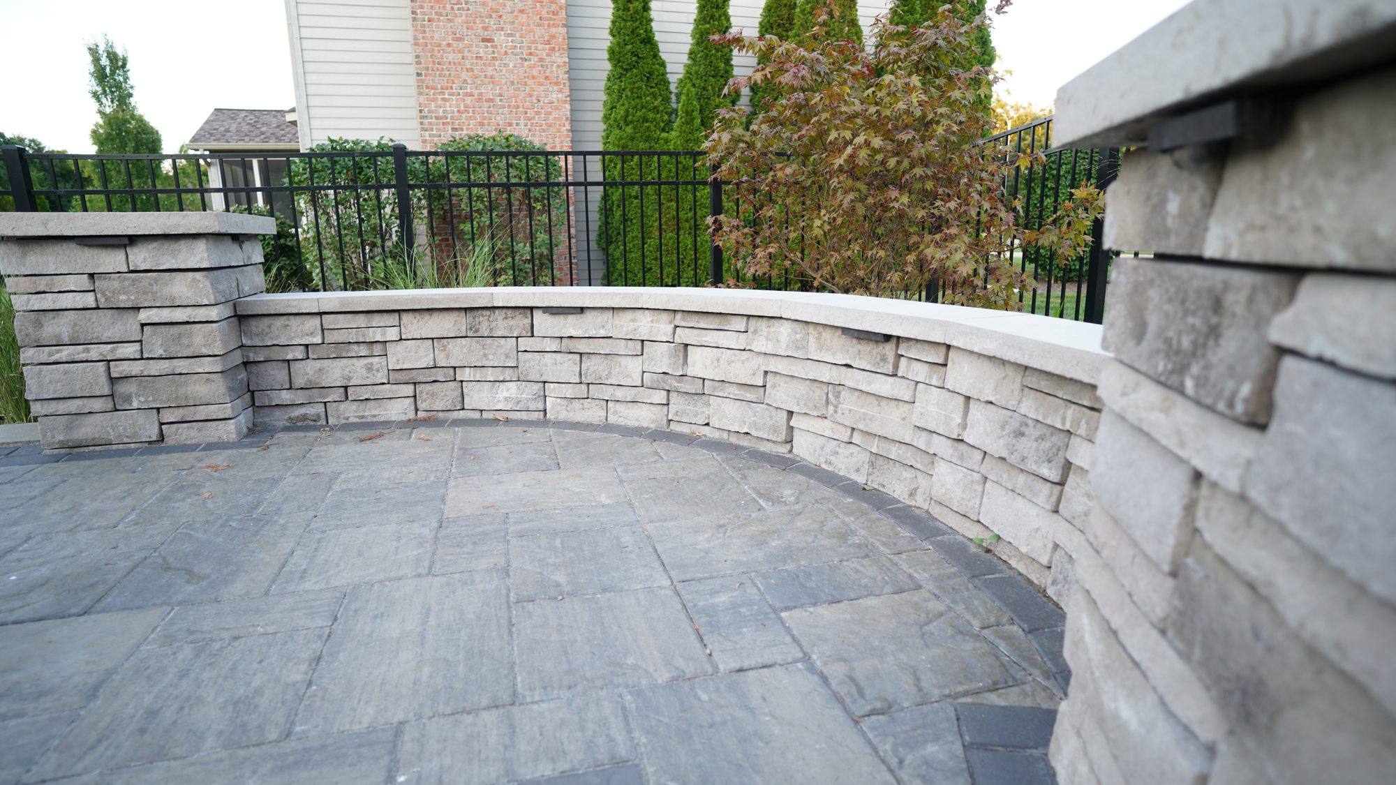 Curved stone seat wall wrapping a paver patio