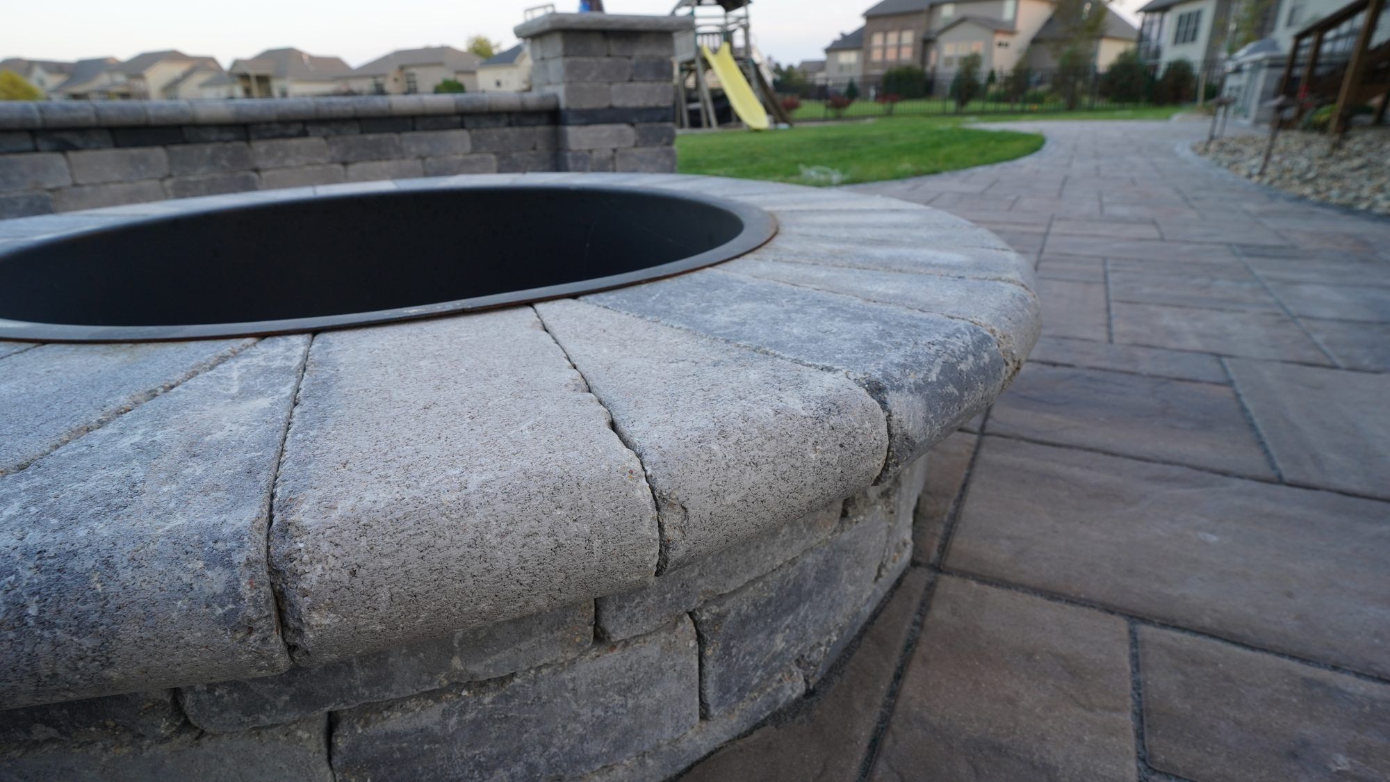 Close-up of a stone fire pit ring on a paver patio