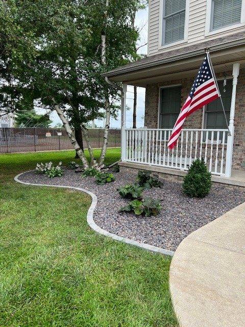 Front yard bed with river rock and curved concrete edging