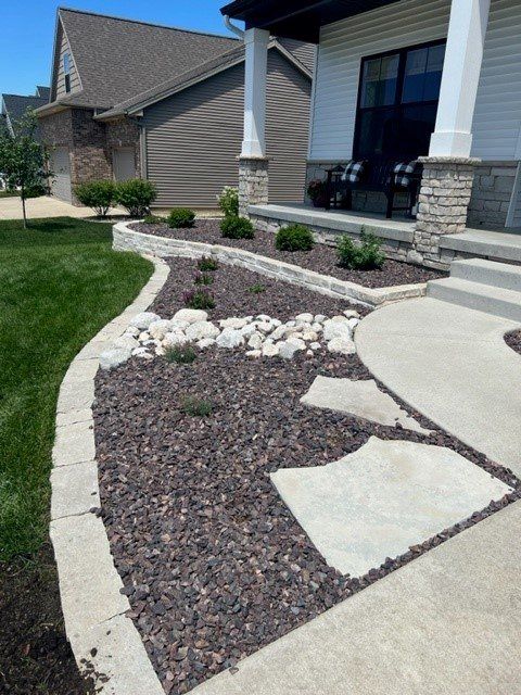 Curved river-rock landscape bed along a front walk