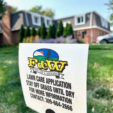 F&W lawn care application sign on a freshly treated front lawn
