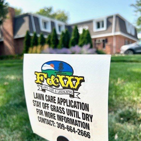 F&W lawn care application sign on a freshly treated front lawn