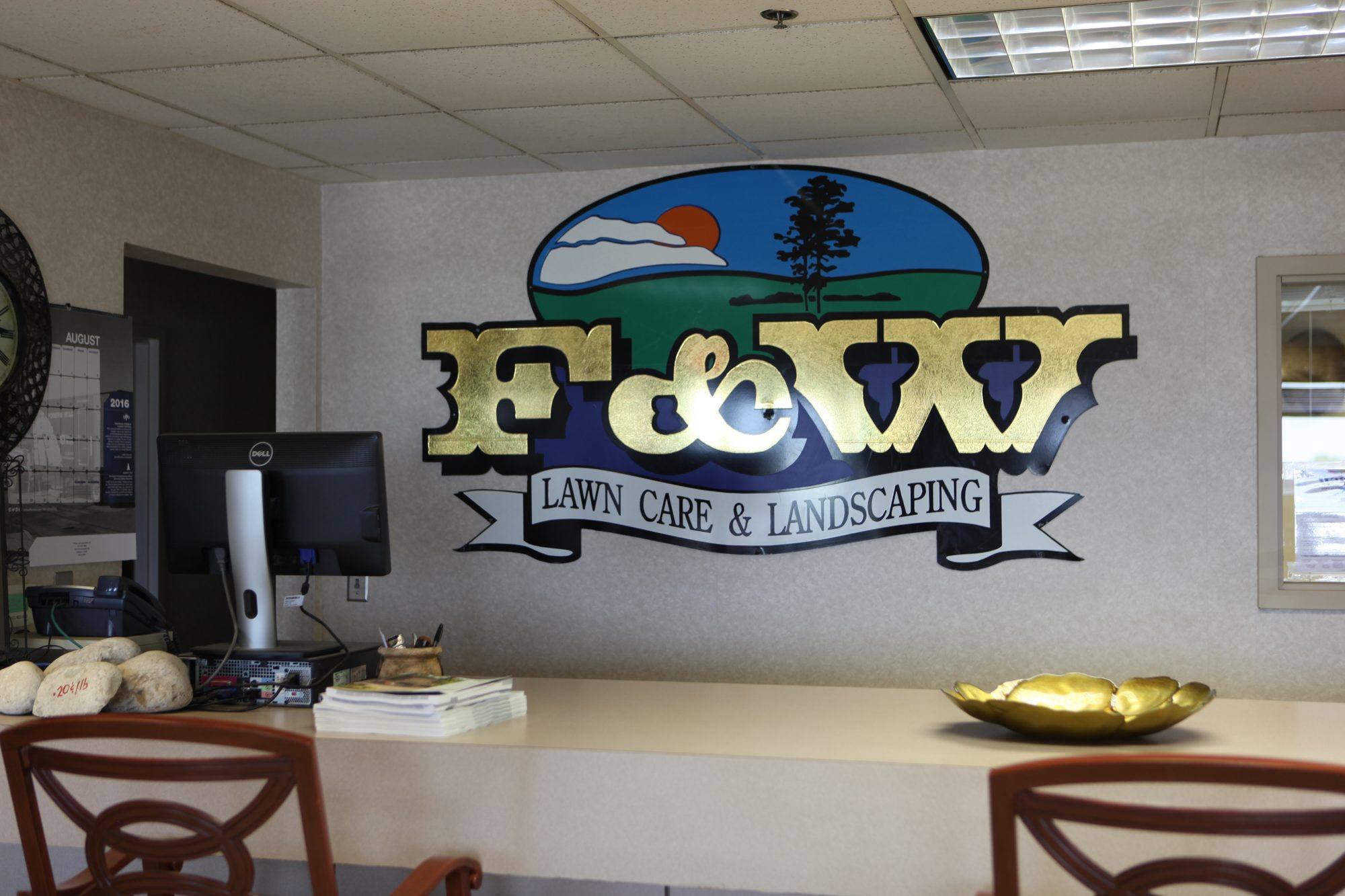 F&W Lawn Care & Landscaping office reception with the company logo on the wall