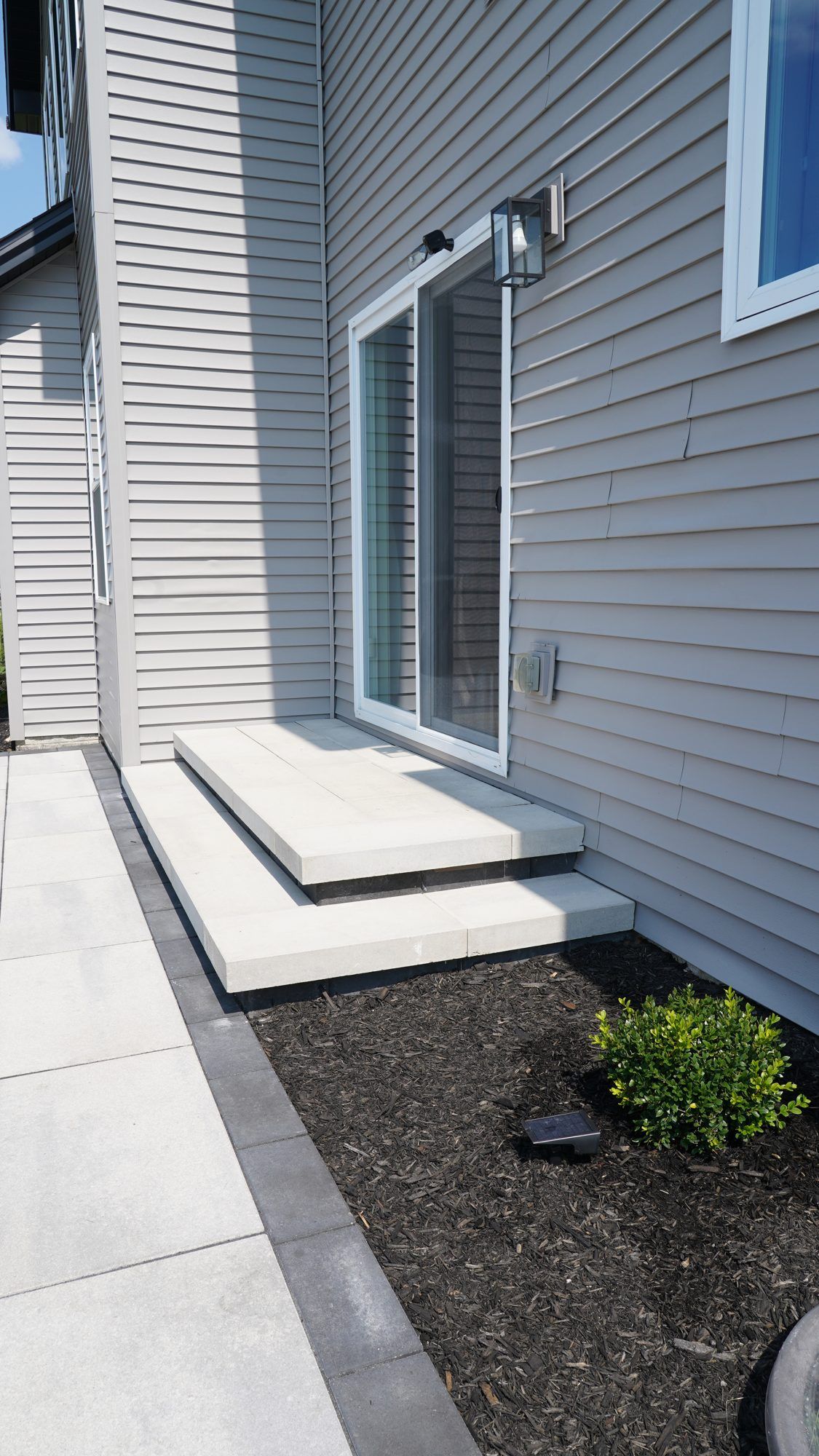 Limestone step and planting bed at a patio door