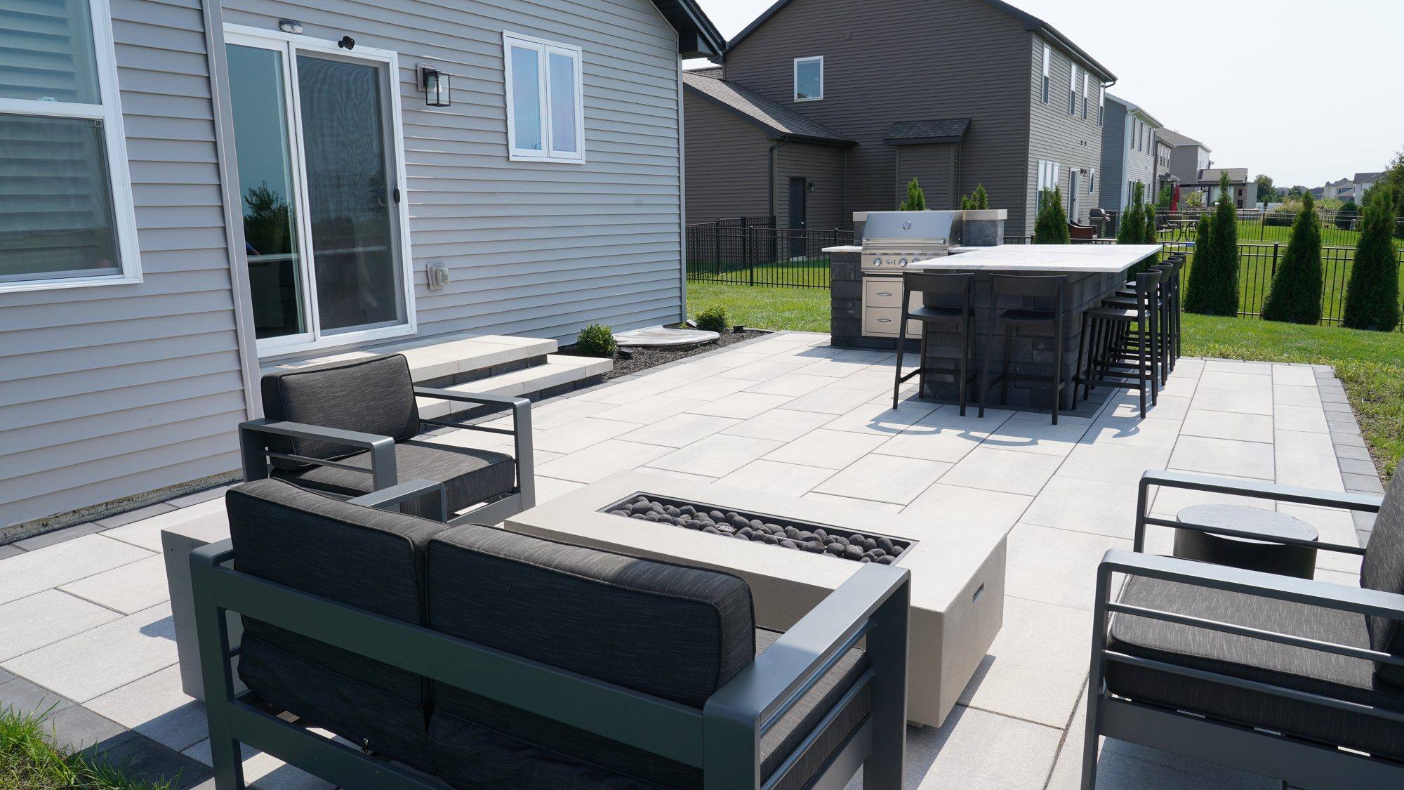 Large modern paver patio with outdoor sofas and dining area