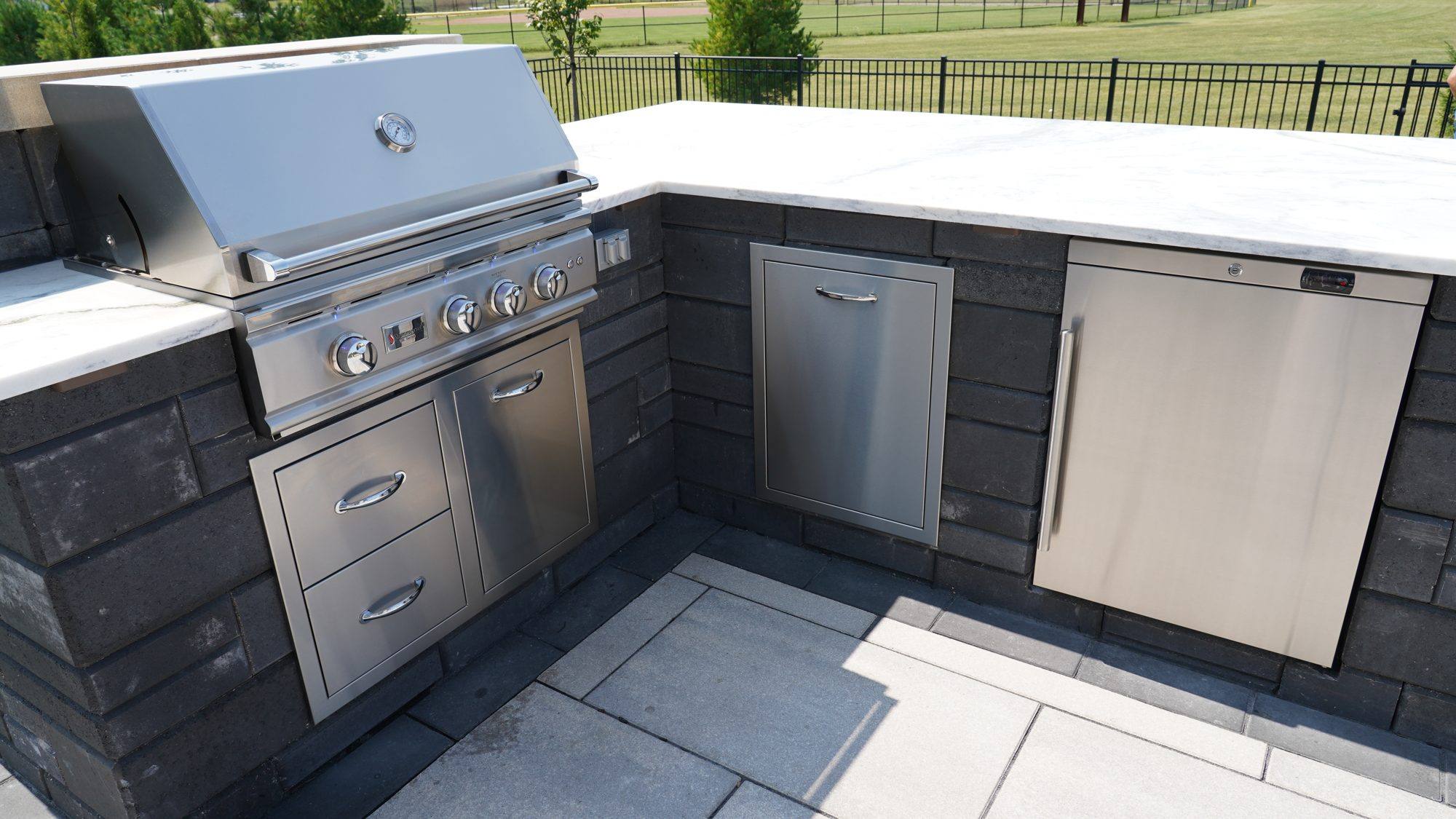 Outdoor kitchen with stainless grill, drawers and access doors