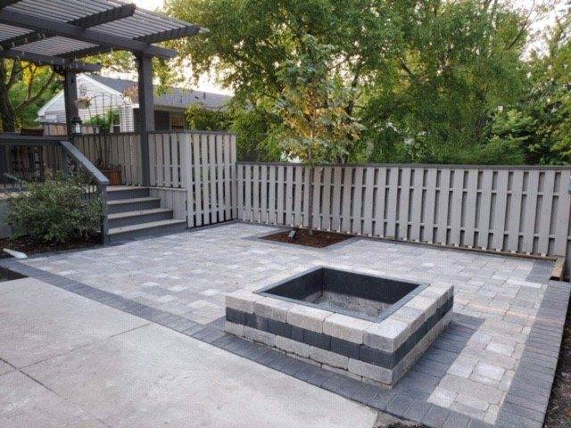 Paver patio with a square sunken fire pit beside a pergola