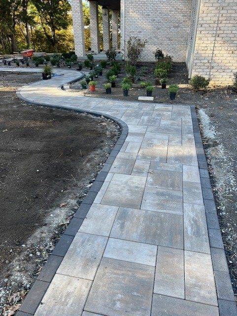 Paver walkway running along the side of a house